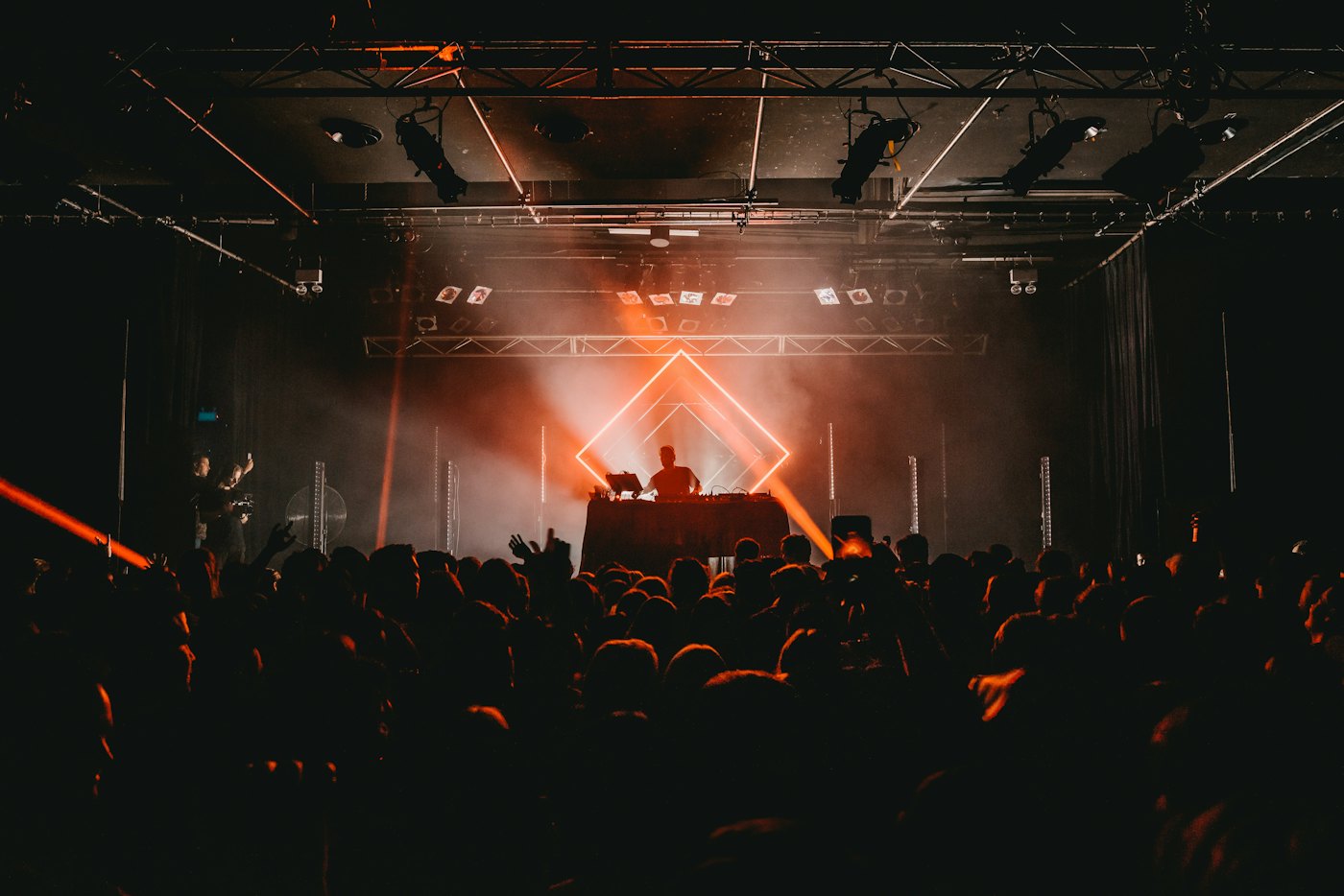 A darkened room with a lit stage and a camera at the side